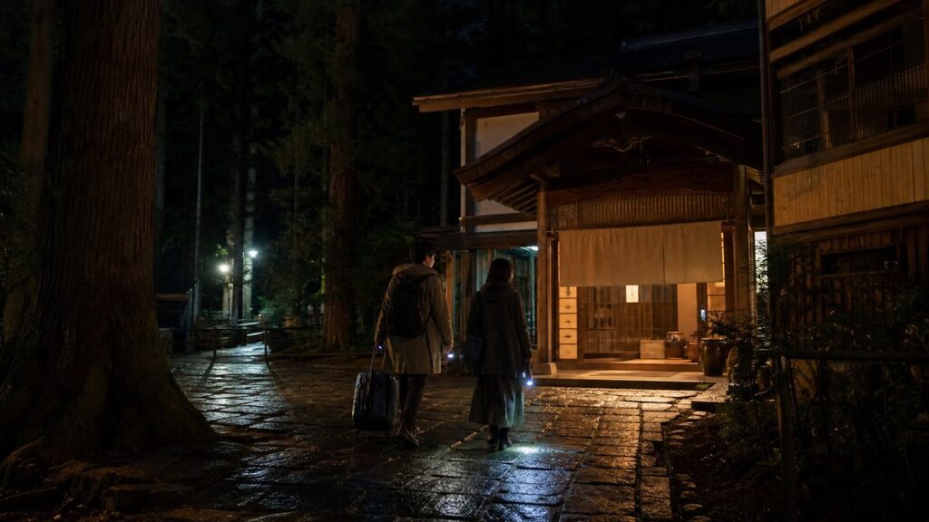 羽黒山門前の木造宿坊へ夜に戻る旅行者を表現したイメージ画像