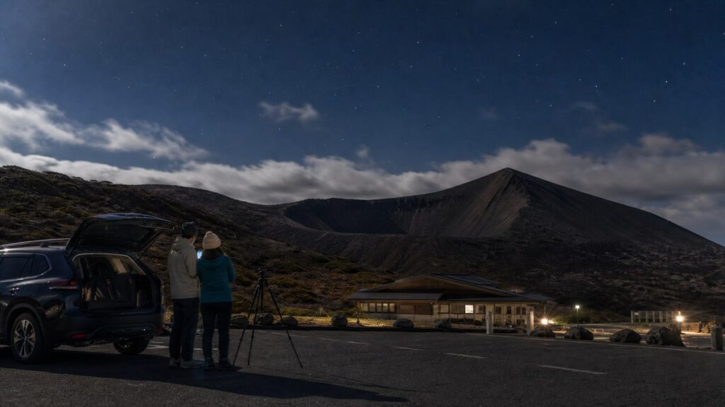 浄土平を想起させる駐車場で吾妻小富士と星空を確認する旅行者のAI生成イメージ