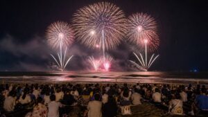 大洗サンビーチの砂浜観覧席から太平洋上の花火を望むAI生成の編集用画像