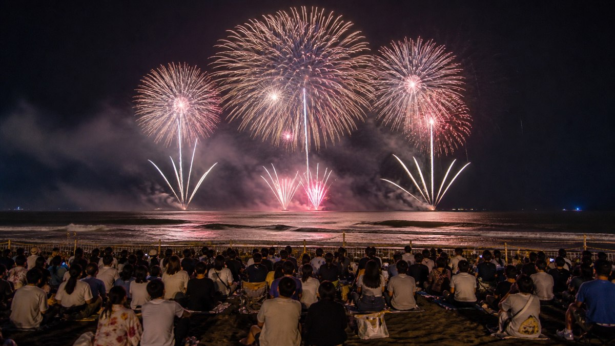 大洗サンビーチの砂浜観覧席から太平洋上の花火を望むAI生成の編集用画像