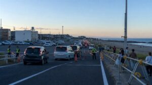 大洗サンビーチ近くの予約駐車場へ誘導される車列を表現したAI生成の編集用画像