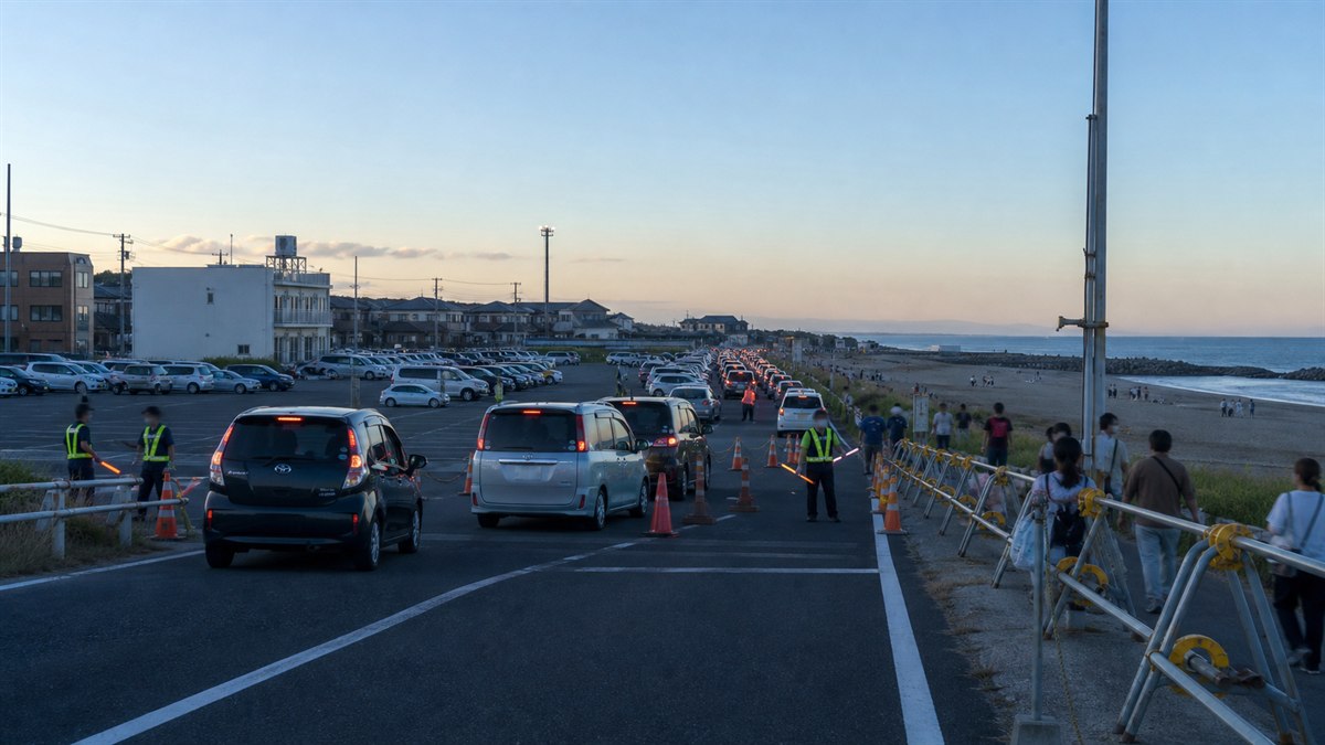大洗サンビーチ近くの予約駐車場へ誘導される車列を表現したAI生成の編集用画像