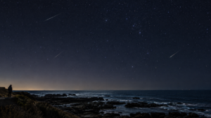 房総の岩礁海岸をイメージした冬の星空と流星（編集用AI生成画像）